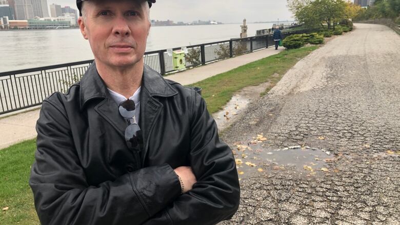 Mike Horoky stands next to a pothole on the riverfront bike trail. He believes it poses a hazard.