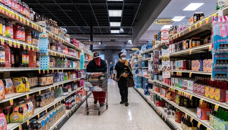 Shoppers browse in a supermarket while wearing masks to help slow the spread of coronavirus disease (COVID-19) in north St. Louis, Missouri.