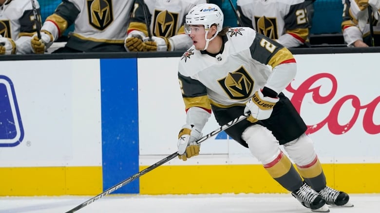 A man on hockey skates with a stick playing the sport on ice. 