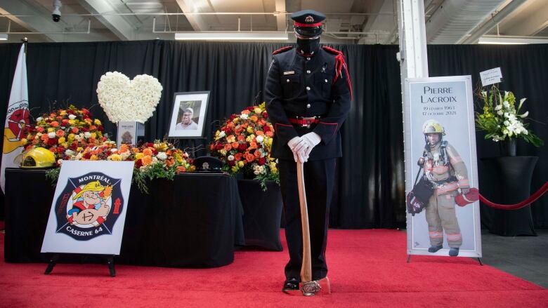 An honour guard bows his head near the casket of a firefighter.