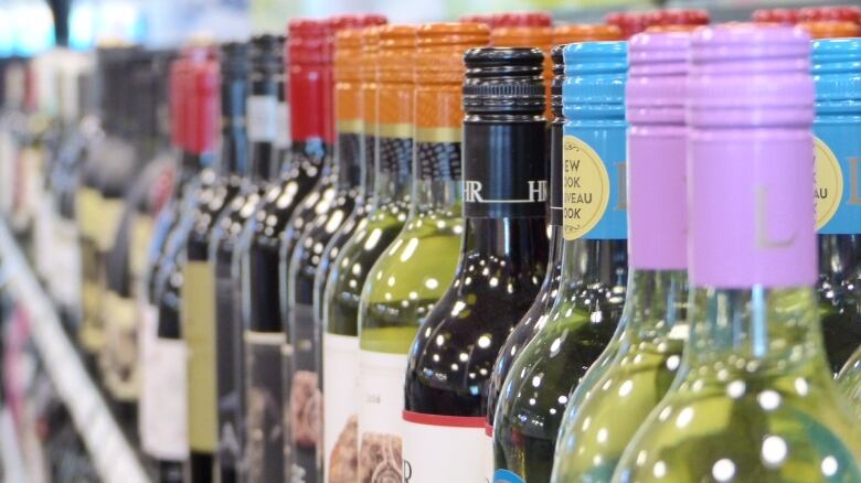 Bottles of wine are shown on a shelf in a store.