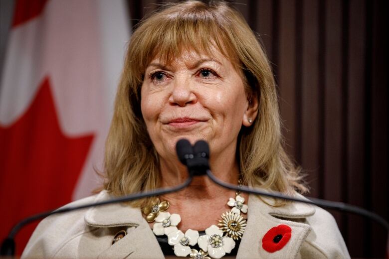 A woman smiles at a podium.