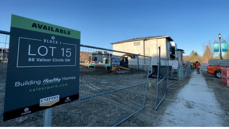 An empty lot next to a newly built house.