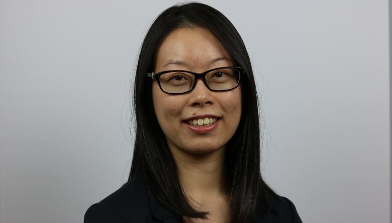 smiling woman with shoulder length dark hair wearing glasses