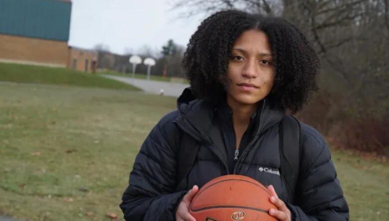 A girl holding a basketball.