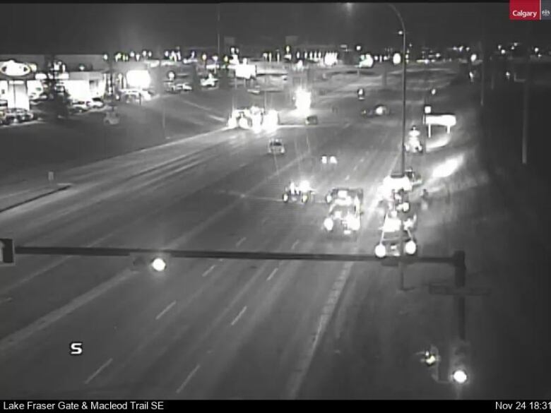 A black and white photo shows the headlights of cars on Macleod Trail where the crash took place.