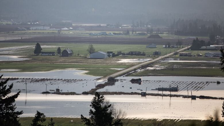 An aerial image of a flooded out farm with ominous clouds in the horizon.