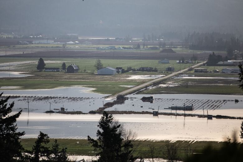 An aerial image of a flooded out farm with ominous clouds in the horizon.