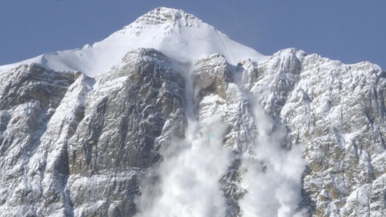 a snowy mountain in front of a clear blue sky