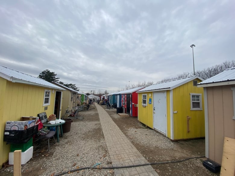 A thin path with a row of tiny homes on each side.