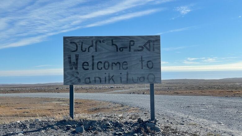 A wooden welcome sign greets visitors to Sanikiluaq, Nunavut, on the outskirts of town.