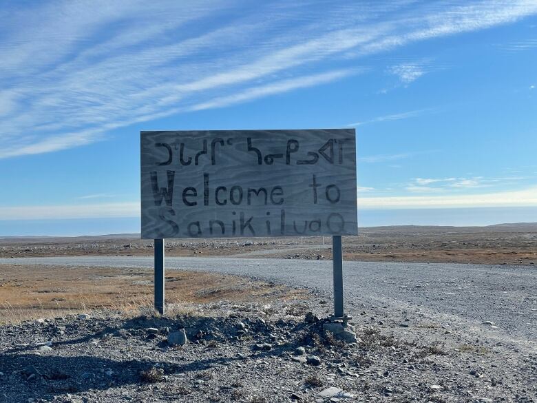 A wooden welcome sign greets visitors to Sanikiluaq, Nunavut, on the outskirts of town.