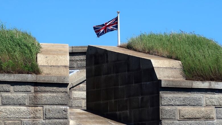 The Union Jack flag flying on top of a series of stone walls