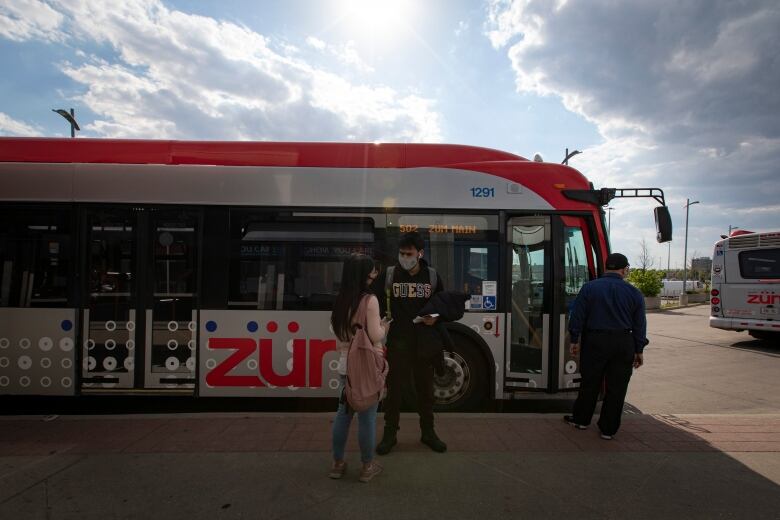 People standing in front of a bus. 