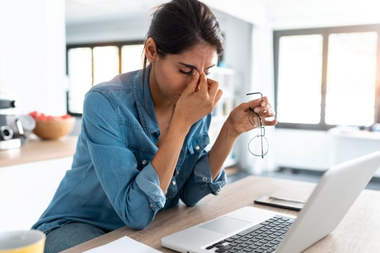 A woman looks frustrated in front of a computer.