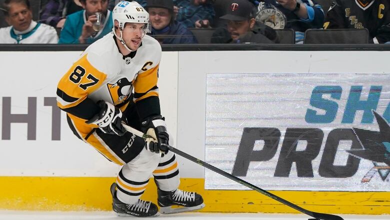 Sidney is seen mid pas while sticking his tongue out the side of his mouth. He's got the puck.