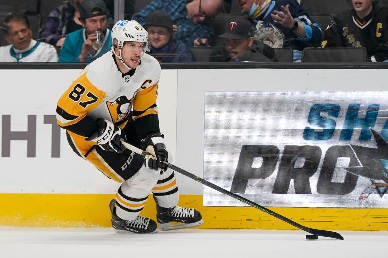 Sidney is seen mid pas while sticking his tongue out the side of his mouth. He's got the puck.