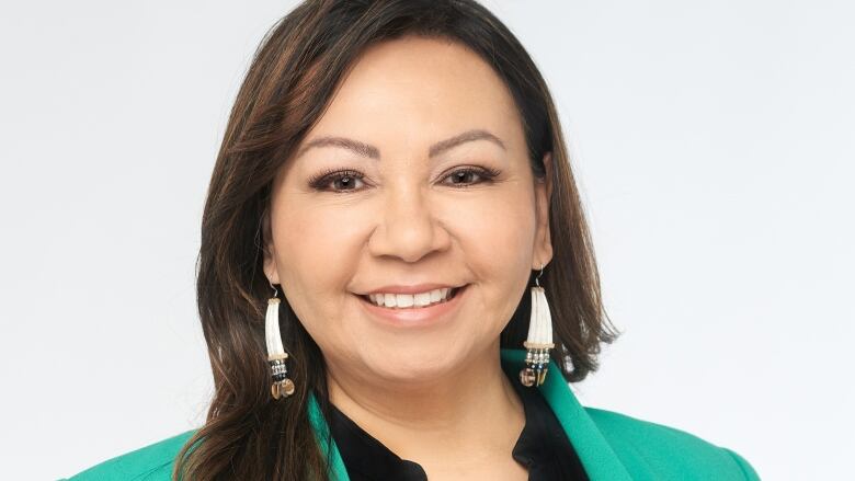 A headshot shows a smiling woman in a green blazer.