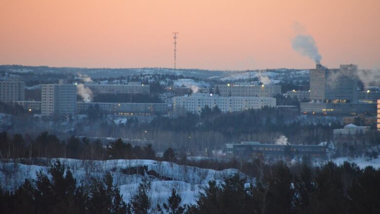 A long shot of the university on the shore of Lake Ramsey with a pink sky