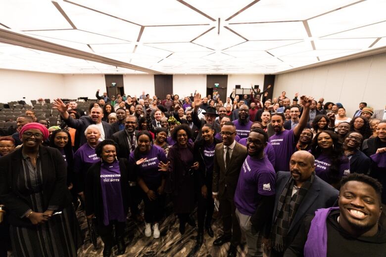 A large group of people wearing purple shirts that read 