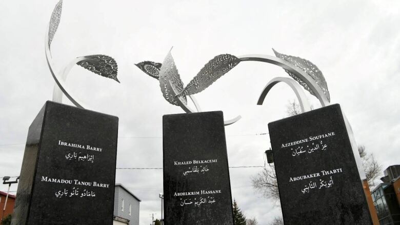 Three monuments printed with the names of six men. 