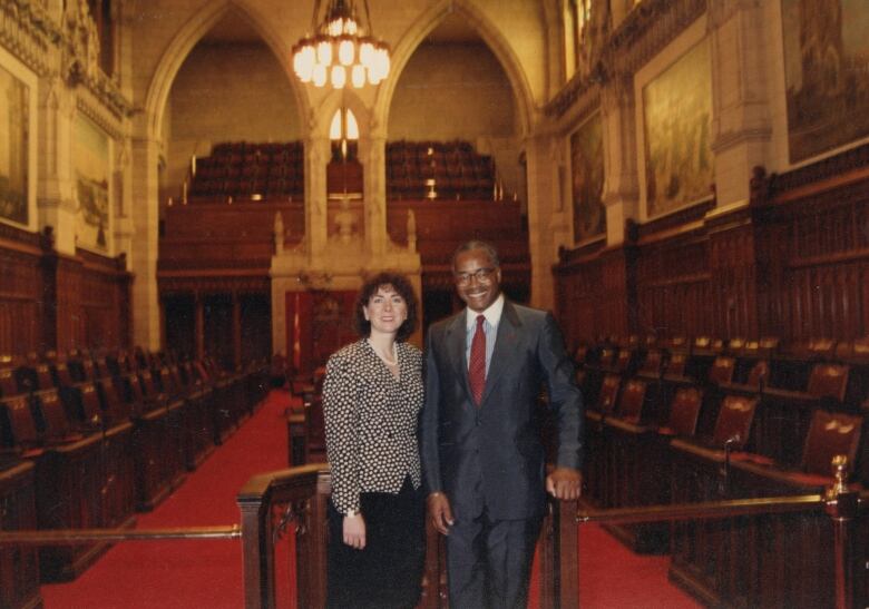 A white woman and a Black man stand in the Senate chambers