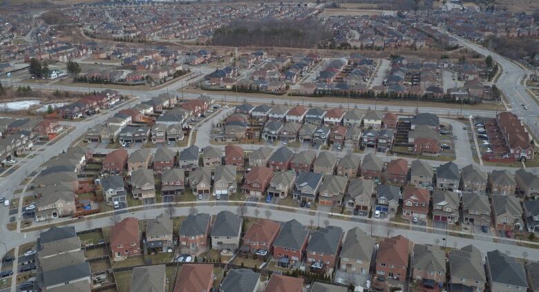 An aerial view of a suburban neighbourhood with houses densley packed together and little greenery in sight