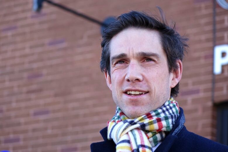 A man with brown hair in a scarf outside Royal Newfoundland Constabulary headquarters in St. John's.