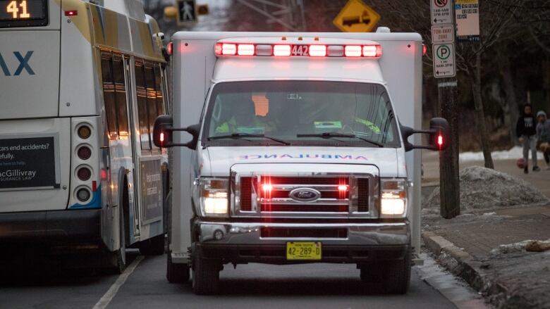 Am ambulance with sirens on busy city street at dusk 