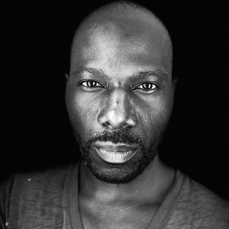 A black and white picture of a man in a V-neck shirt.