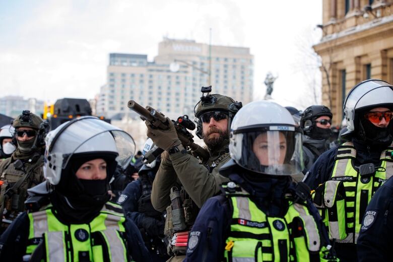 Police enforce an injunction against protesters, some who have been camped in their trucks near Parliament Hill for weeks, on Feb. 19, 2022.