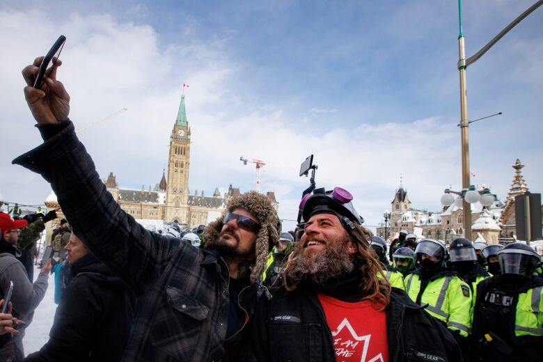 Two men take a selfie during a protest in front of Parliament Hill in Ottawa.