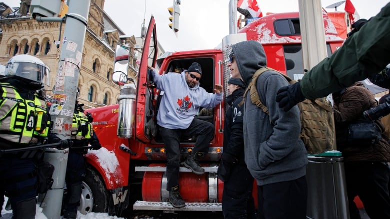 A man is stepping out of a heavy truck