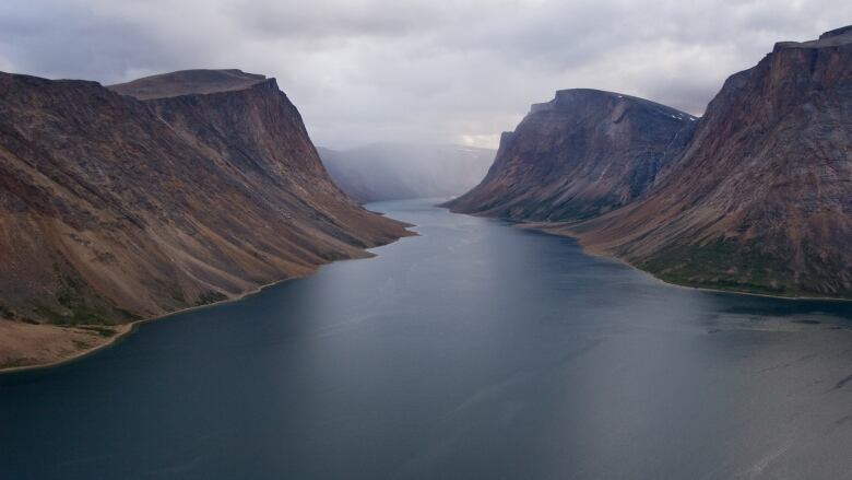 Water flows between mountains. 