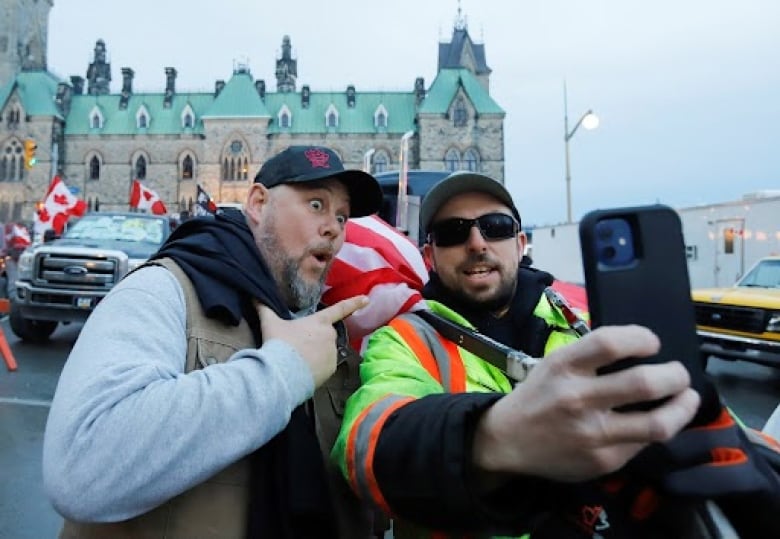 Pat King, left, one of the organizers of the protest, poses for photos in front of Parliament Hill as truckers and their supporters continue to protest against coronavirus disease (COVID-19) vaccine mandates in Ottawa, Ontario, Canada, February 16, 2022. 