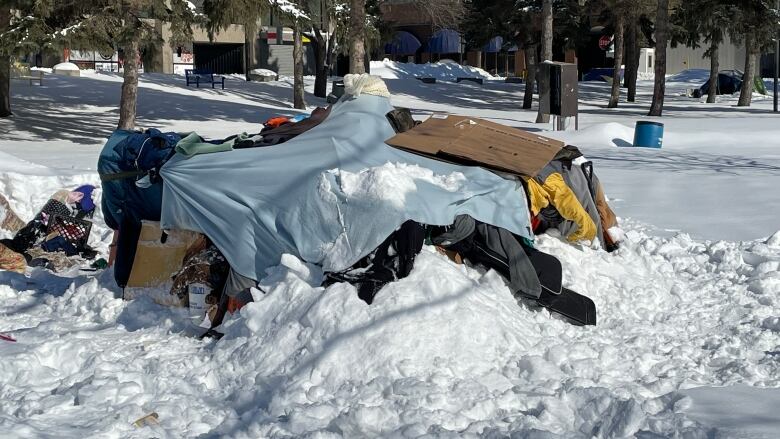 A makeshift tent convered in snow.