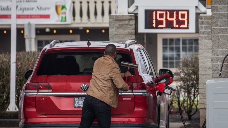 A man is pictured filling his cars with gas at a gas station in Surrey, B.C., on March 3, 2022.