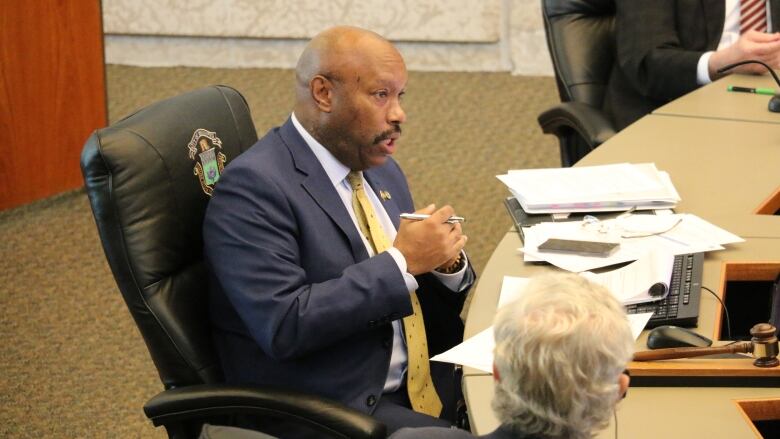 A man speaks in a city council meeting.