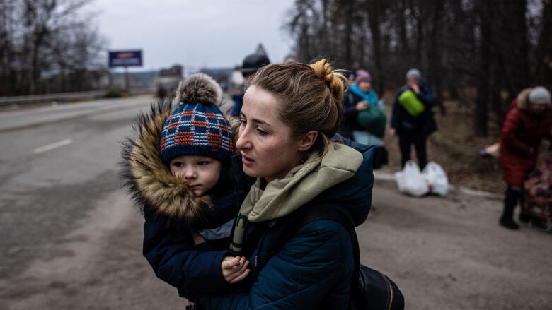 A woman carries her child.