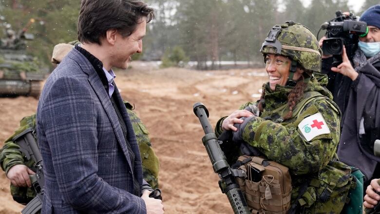 Prime Minister Justin Trudeau talks with a Canadian soldier during his visit to Adazi Military base in Kadaga, Latvia on Tuesday, March. 8, 2022.