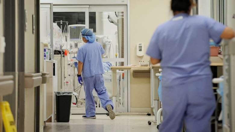 A hospital setting with two nurses in blue scrubs