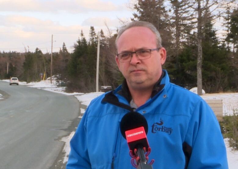 A man with grey hair and a blue jacket.