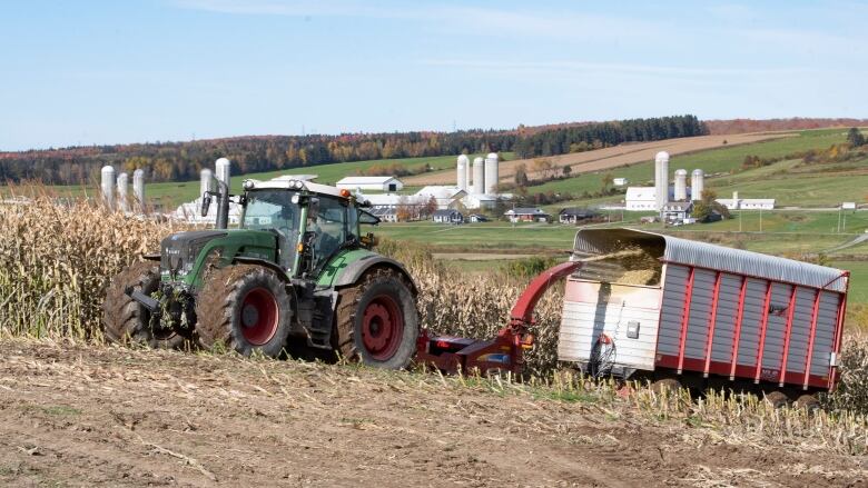 A tractor pulling hay through a field. 