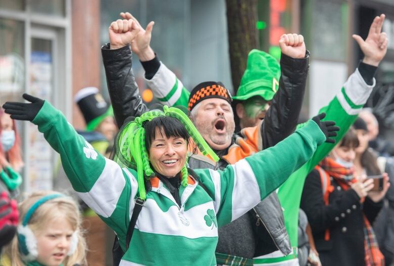 A woman and man dressed in green cheer at the St. Patricks Day parade in Montreal.