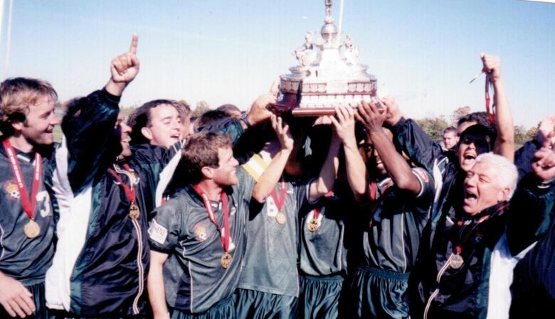 A group of people holding a trophy up