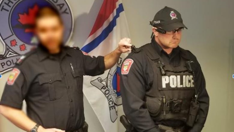 Two men in a police uniform stand next to each other. 