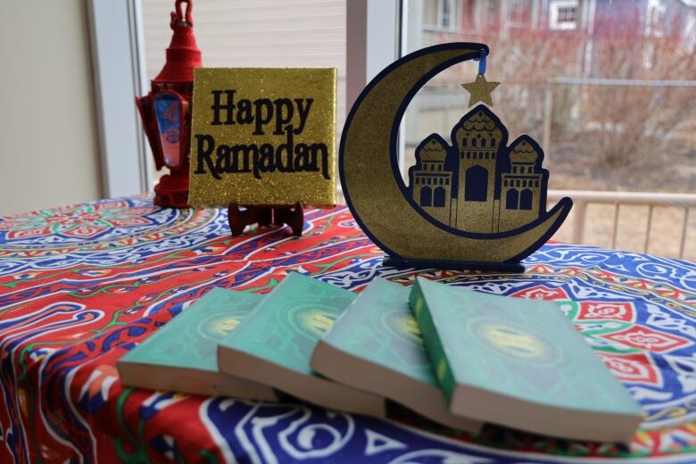 A Ramadan display with a sign and a cutout crescent moon and a mosque.