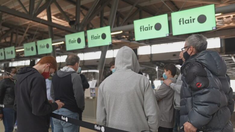 People stand at an airport.