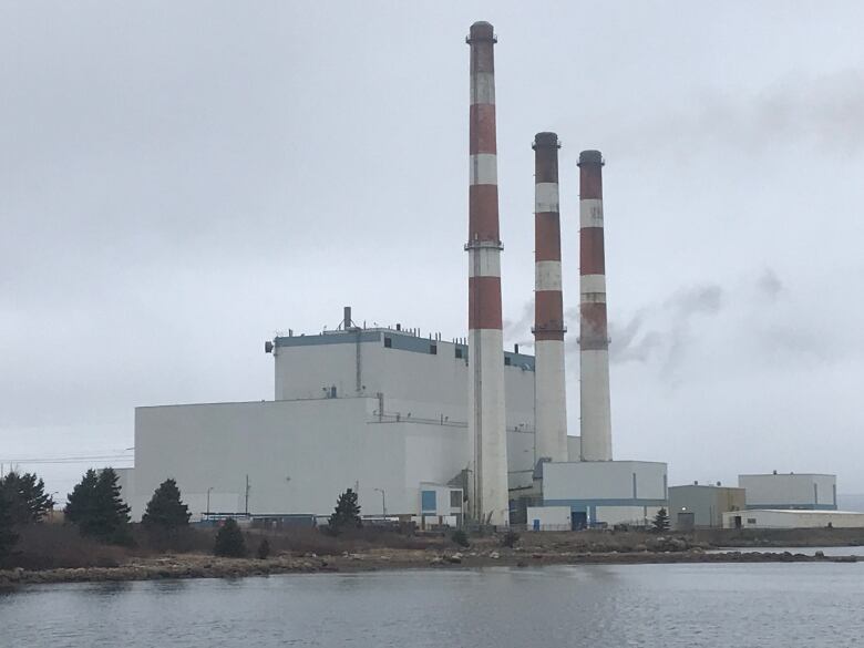 Grey day with power station along water.