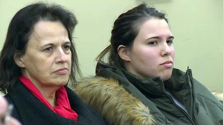 two women sitting in their coats